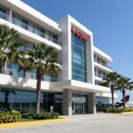 Airport hotel in Labuan Bajo with palm trees and airplane.